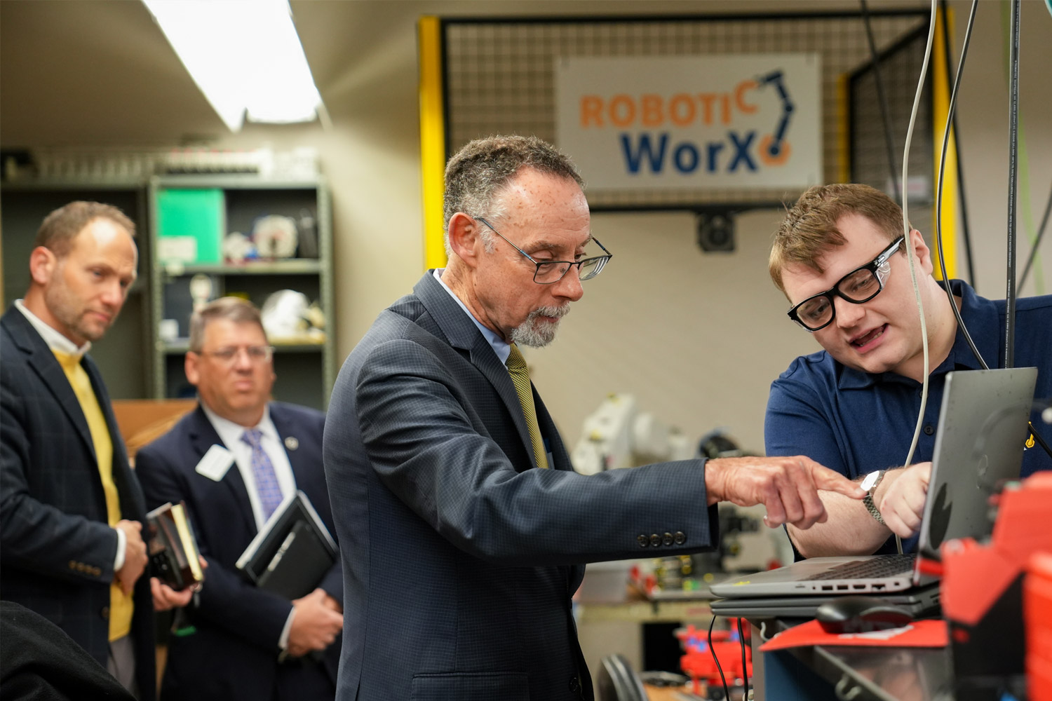 A Millersville University engineering student shows Chancellor Fiorentino the Robitic Worx lab. 