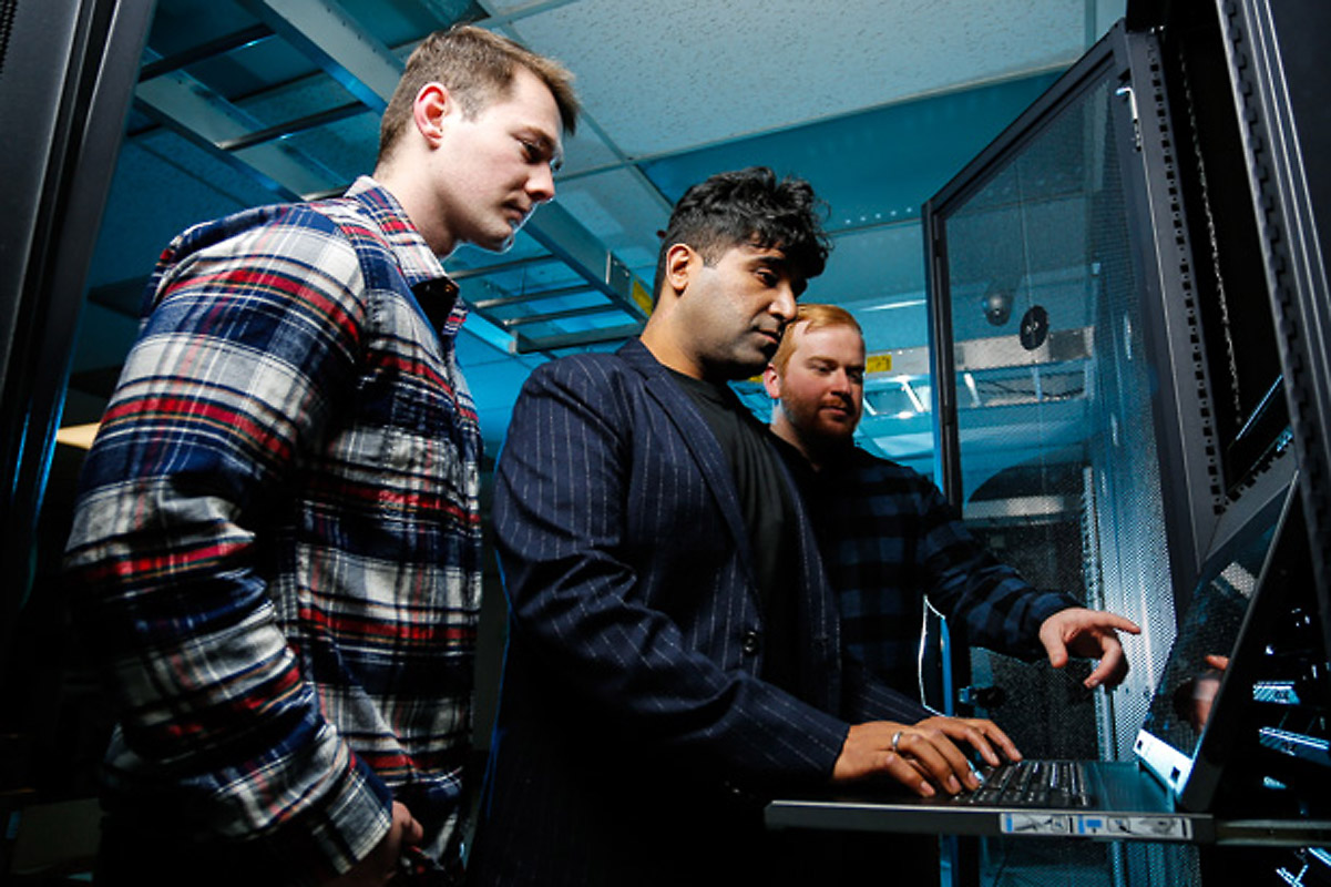 Nitin Sukhija in a classroom lab with two Slippery Rock University cybersecurity students.